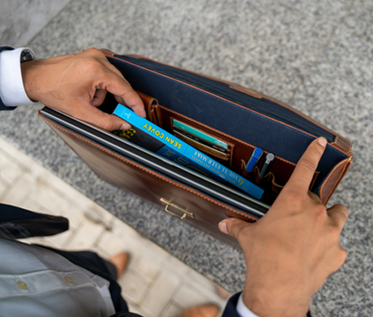 man holding a brown leather laptop messenger bag